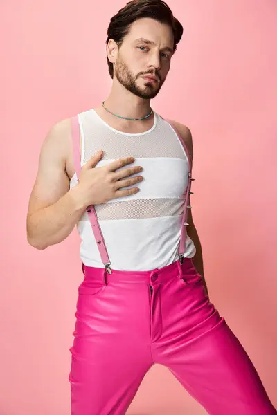 A model confidently showcases bold LGBTQ fashion in vibrant pink against a matching backdrop. — Stock Photo