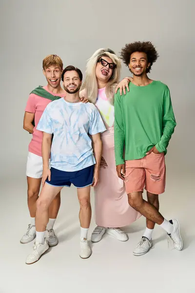Four joyful individuals express their pride in colorful outfits while posing together. — Stock Photo