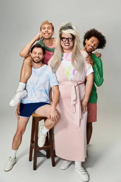 Four individuals joyously pose together, showcasing vibrant outfits and lively expressions. — Stock Photo