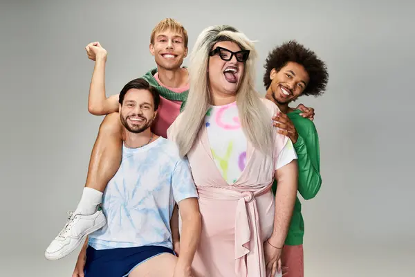 Four friends joyfully pose in colorful outfits, representing queer culture and pride in a studio. — Stock Photo