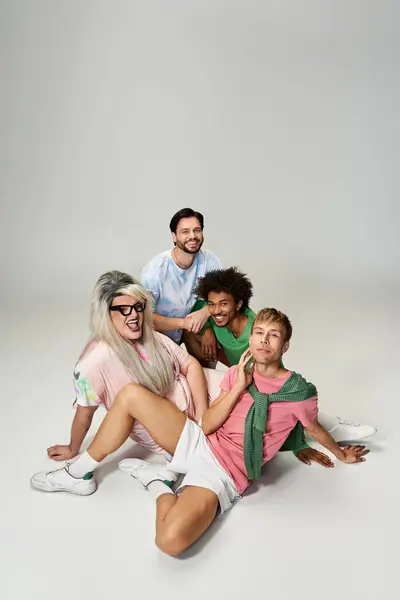 Four friends express joy through laughter and vibrant outfits in a playful setting together. — Stock Photo