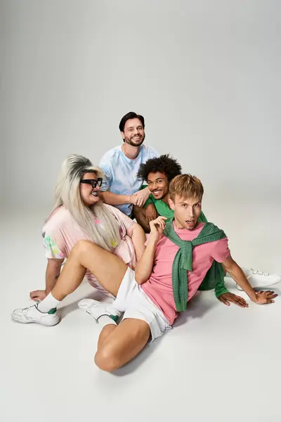 Four friends joyfully pose in colorful outfits, showcasing their pride in a studio. — Stock Photo