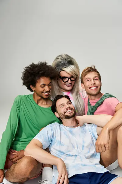 A group of four friends joyfully posing together, showcasing vibrant outfits and smiles. — Stock Photo