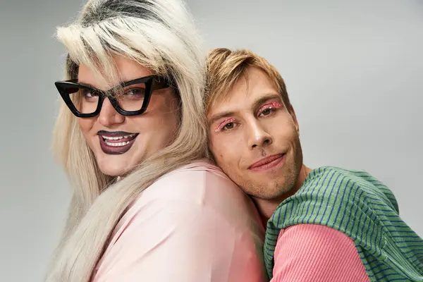 Two friends joyfully embrace while showcasing bold, colorful outfits that celebrate pride. — Stock Photo
