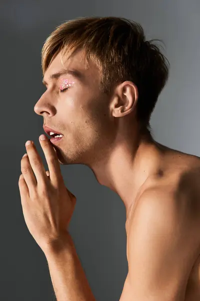 Person showcases a vibrant queer identity with artistic makeup and a thoughtful expression. — Stock Photo