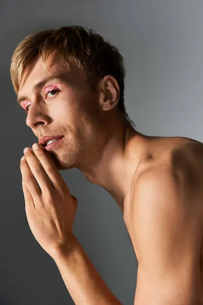 A person flaunts vibrant makeup and a confident pose, celebrating queer identity. — Stock Photo