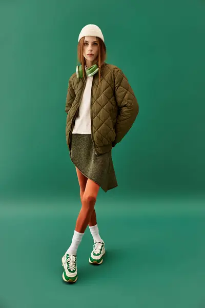 Une jeune femme se tient en confiance, mettant en valeur son style unique dans un contexte vert. — Photo de stock
