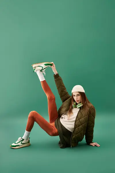 Une jeune femme met en valeur sa mode et sa résilience dans un contexte vert vibrant. — Photo de stock