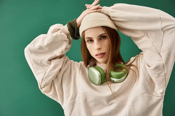 A young woman wearing a beanie and oversized sweater depicts her struggle with anorexia. — Stock Photo