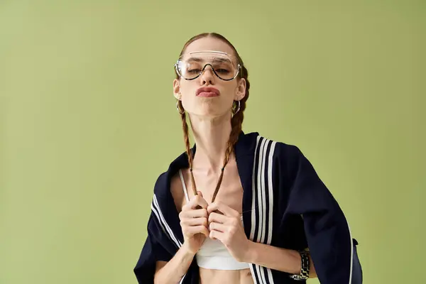 Confident young woman with braids stands out against a vibrant green backdrop. — Stock Photo