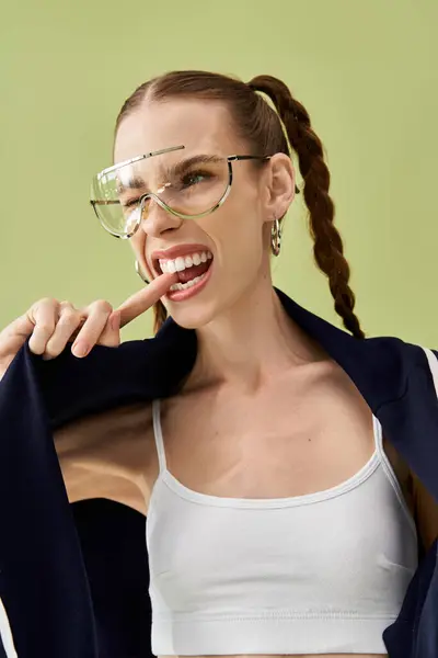 A young woman confidently poses with a playful expression, wearing stylish accessories. — Stock Photo