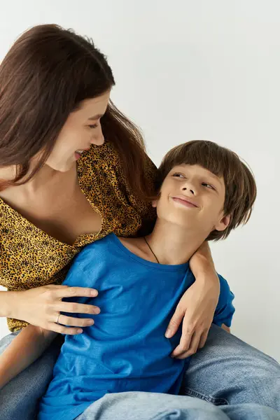 Una joven madre interactúa alegremente con su hijo en un espacio de estudio casual, mostrando su vínculo. - foto de stock