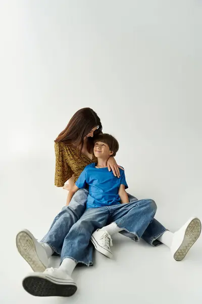 A young mother and her son enjoy a playful moment together in a bright studio. — Stock Photo