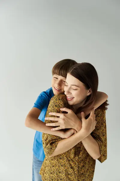 A young mother and her son share a warm embrace, showcasing their bond in a stylish studio. — Stock Photo