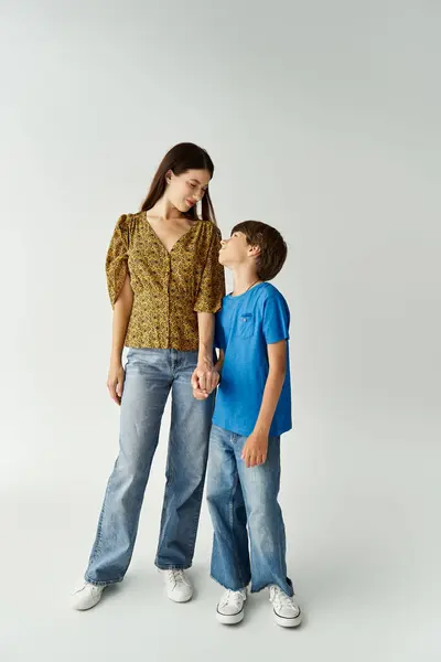 A young mother and her son share a joyful moment in casual attire, highlighting family bonds. — Stock Photo