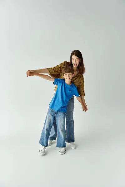 Una joven madre y su hijo comparten un momento lúdico en un estudio luminoso, disfrutando de su tiempo juntos. - foto de stock