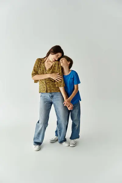 A young mother and her son enjoy a playful moment while dressed casually in a modern studio. — Stock Photo