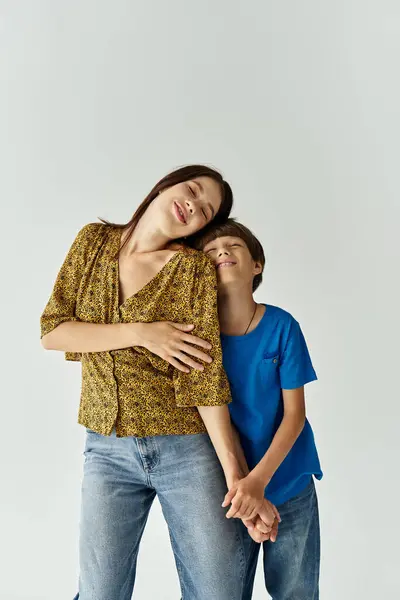 Una joven madre y su hijo comparten un momento lúdico en un espacio de estudio minimalista. - foto de stock