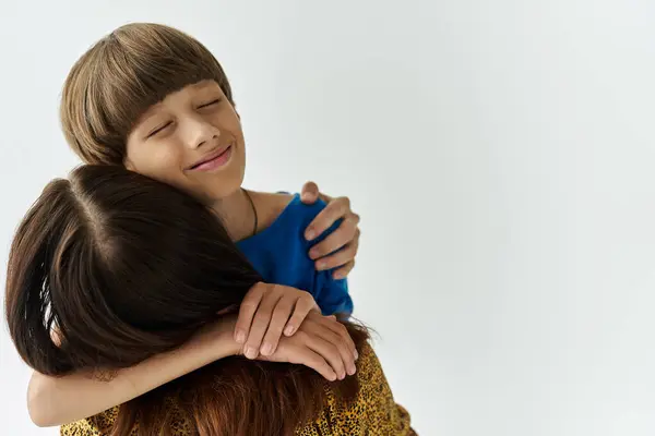 A young mother shares a heartfelt hug with her son in a simple studio filled with love. — Stock Photo