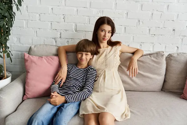 Mom and son relax together on the couch in a cozy, modern living room filled with love. — Stock Photo