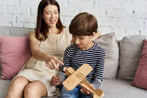 Une mère et son fils partagent un moment agréable en jouant ensemble dans leur espace de vie moderne. — Photo de stock