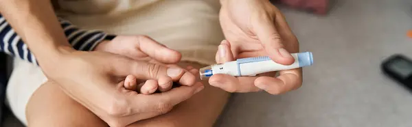 Young mother helps her son check blood sugar levels at home, banner — Stock Photo