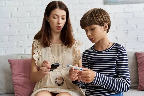 In a cozy living room, a young mother explains diabetes management to her son. — Stock Photo
