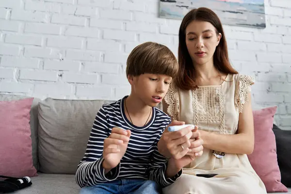 Young mother and her son engage in diabetes management together at home, fostering connection. — Stock Photo