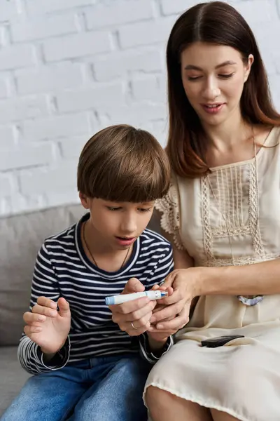 In a modern living room, a young mother lovingly instructs her son about diabetes management. — Stock Photo