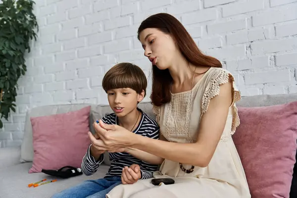A young mother explains blood sugar management to her son in their cozy living room. — Stock Photo