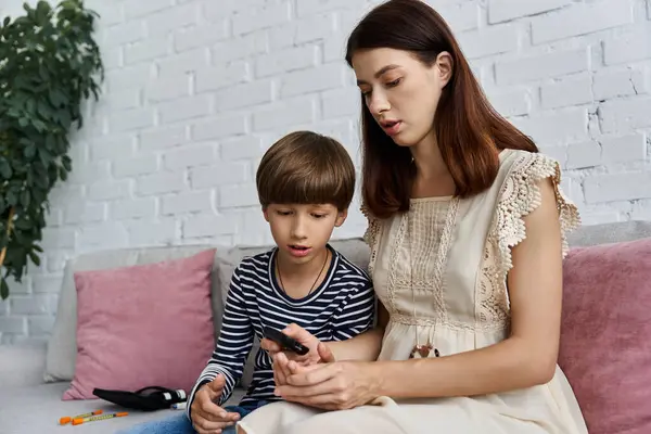 Mother guides her young son in monitoring diabetes levels in their modern living room. — Stock Photo