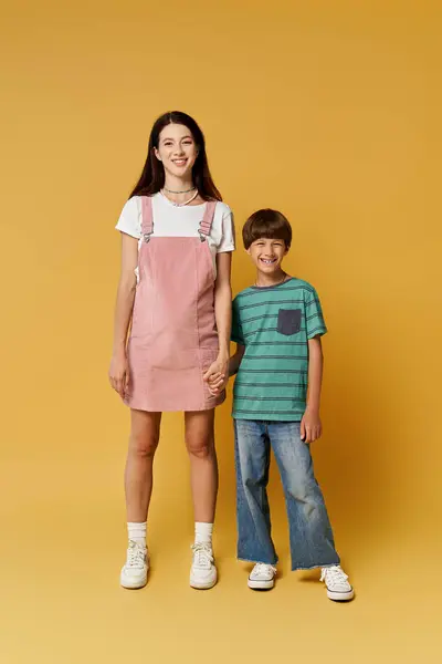 Una madre y su hijo están juntos, radiantes de felicidad en un brillante fondo de estudio. - foto de stock
