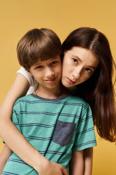 Una joven madre abraza a su hijo en un alegre estudio lleno de calor y amor. - foto de stock