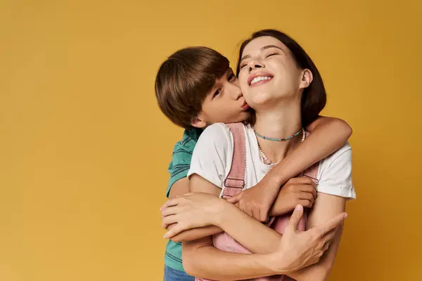 Mother and son share a playful embrace in a warm, modern studio setting filled with joy. — Stock Photo