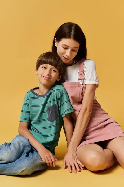 A young mother lovingly sits next to her smiling son in a warm and inviting studio space. — Stock Photo