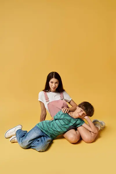 Mother and son share a joyful moment in casual attire against a vibrant backdrop. — Stock Photo
