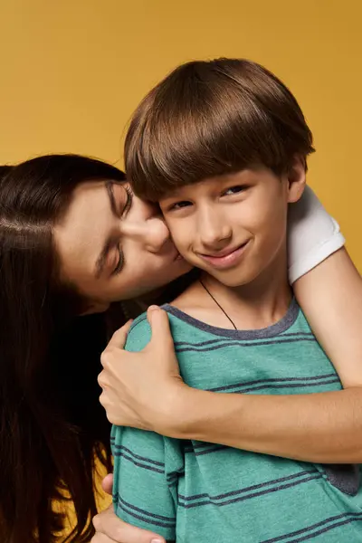 Eine Mutter umarmt ihren Sohn mit Liebe und Freude in einem hellen Atelierraum und zeigt ihre Verbundenheit. — Stockfoto