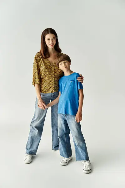 A young mother and her son stand together in casual outfits, embracing family love and connection. — Stock Photo