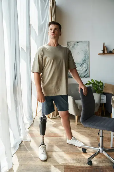 Handsome young man poses with a prosthetic leg in a stylish indoor setting during daylight. — Stock Photo