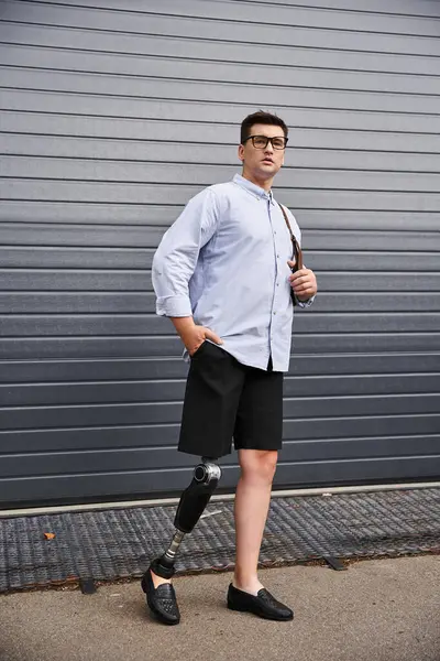 Handsome young man stands stylishly with a prosthetic leg, exuding confidence and poise. — Stock Photo