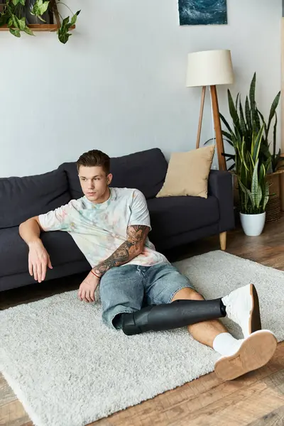 Jovem lounges confortavelmente em um tapete acolhedor em uma elegante sala de estar, mostrando sua perna protética. — Fotografia de Stock