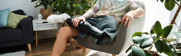 A young handsome man relaxes in a cozy living room while showcasing his unique prosthetic leg. — Stock Photo