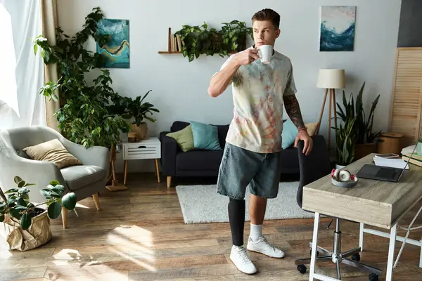 In a cozy room, a young man with a prosthetic leg enjoys his coffee, radiating confidence. — Stock Photo