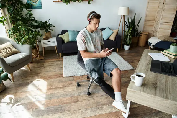 Handsome young man relaxing at home, using phone with focus while seated comfortably. — Stock Photo