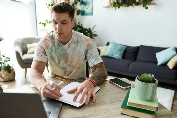 A young man is focused on his work at a bright, cozy home office setting. — Stock Photo