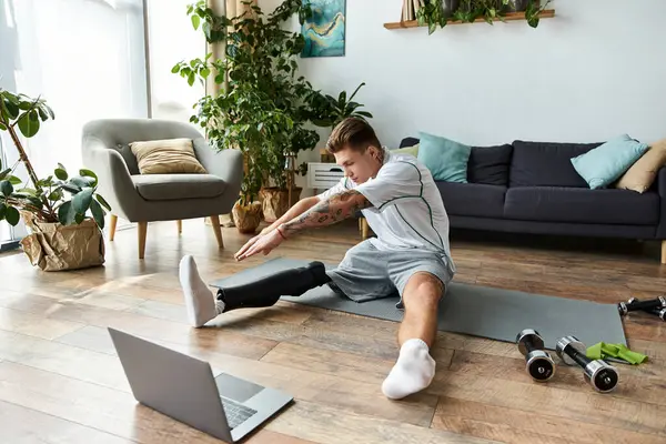 A young man stretches at home on a mat, highlighting his prosthetic leg and fitness. — Stock Photo