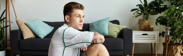 Молодий красивий чоловік сидить задумливо в стильній кімнаті. — Stock Photo