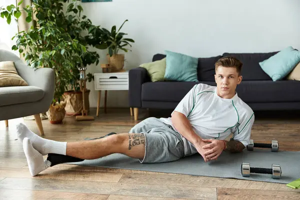 Determined young man working out on a mat at home, showcasing strength and resilience. — Stock Photo