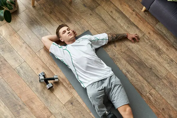 Young man rests after an intense workout session, showcasing resilience and determination. — Stock Photo