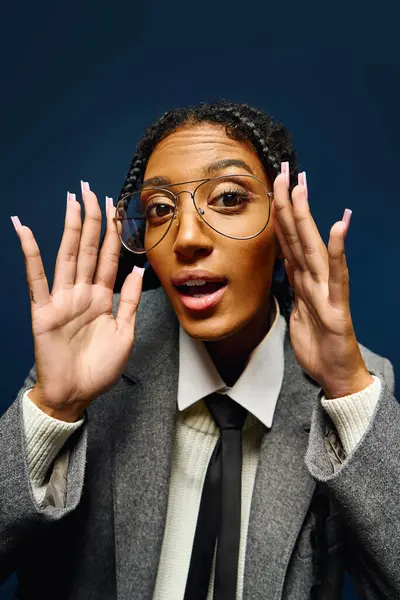 Junge Frau mit Brille gestikuliert freudig im Maßanzug und strahlt Charisma aus. — Stockfoto